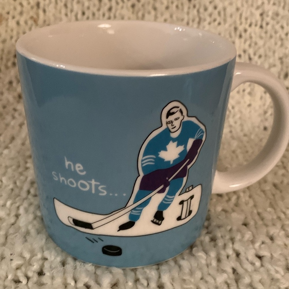 Hockey mug, blue with male hockey player on it.